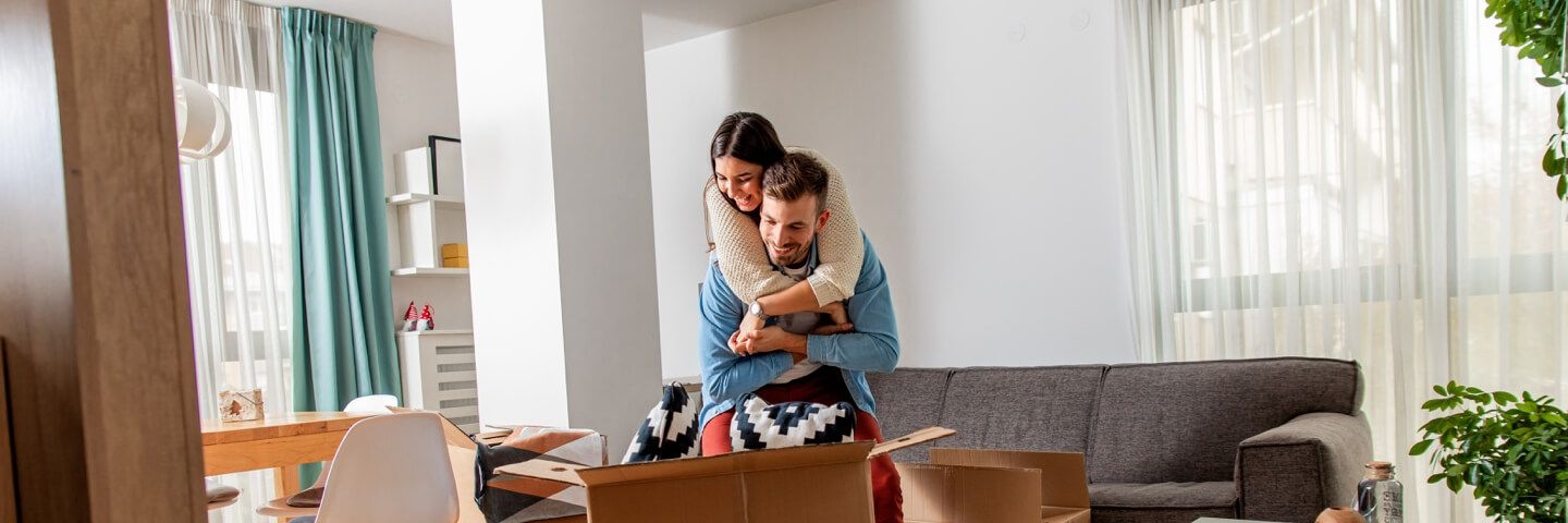 Couple in living room unpacking boxes